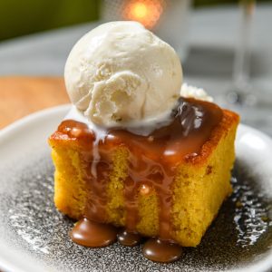 a warm square of her decadent, buttery sweet treat with warm caramel, vanilla ice cream & whipped cream